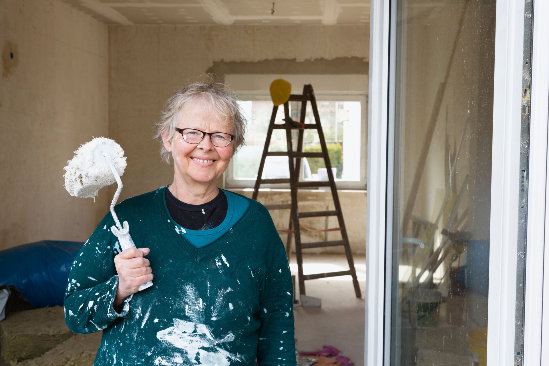 senior woman painting her new house happiness