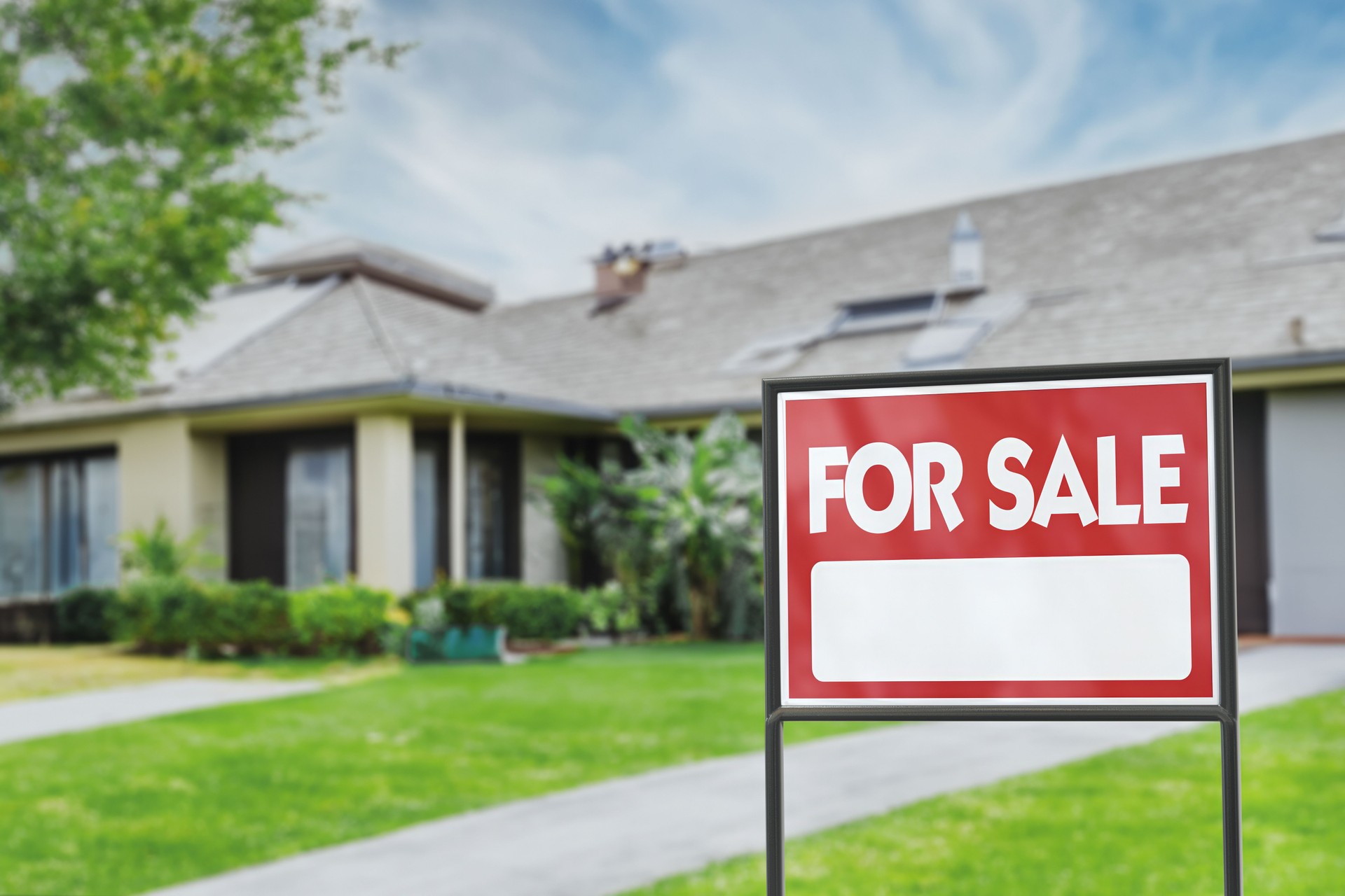 Real Estate Sign in Front of a House with a Garden for Sale