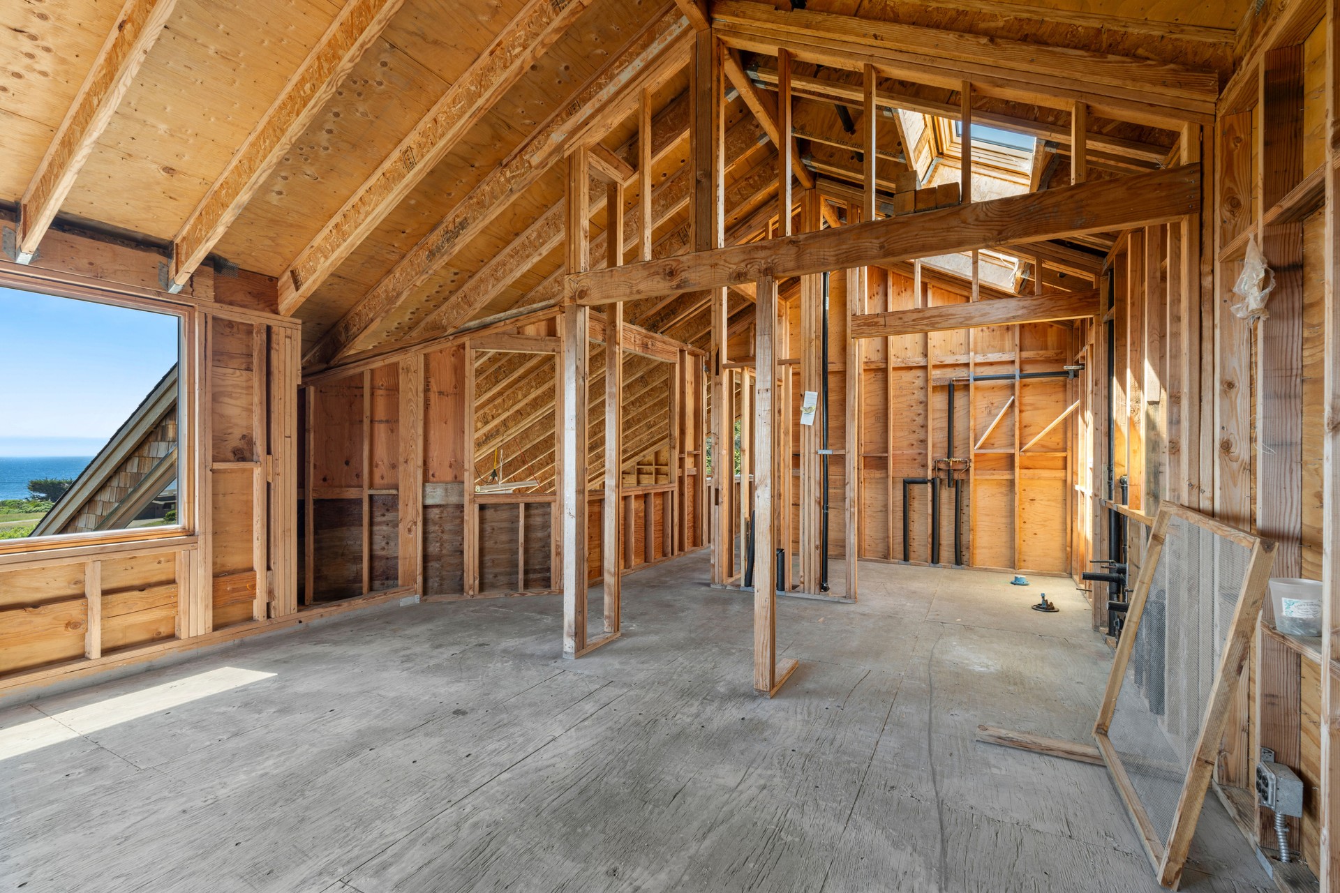 Home interior with wood framing under construction and ocean view